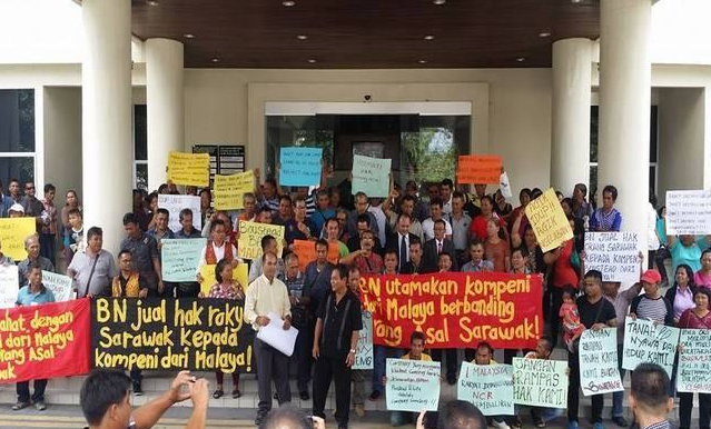 Native protesters hold banners demanding their native rights be recognised.