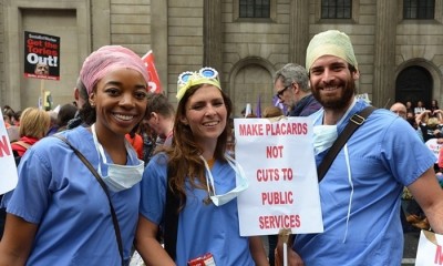 Cheerful doctors and nurses make their protest against health cuts in London.